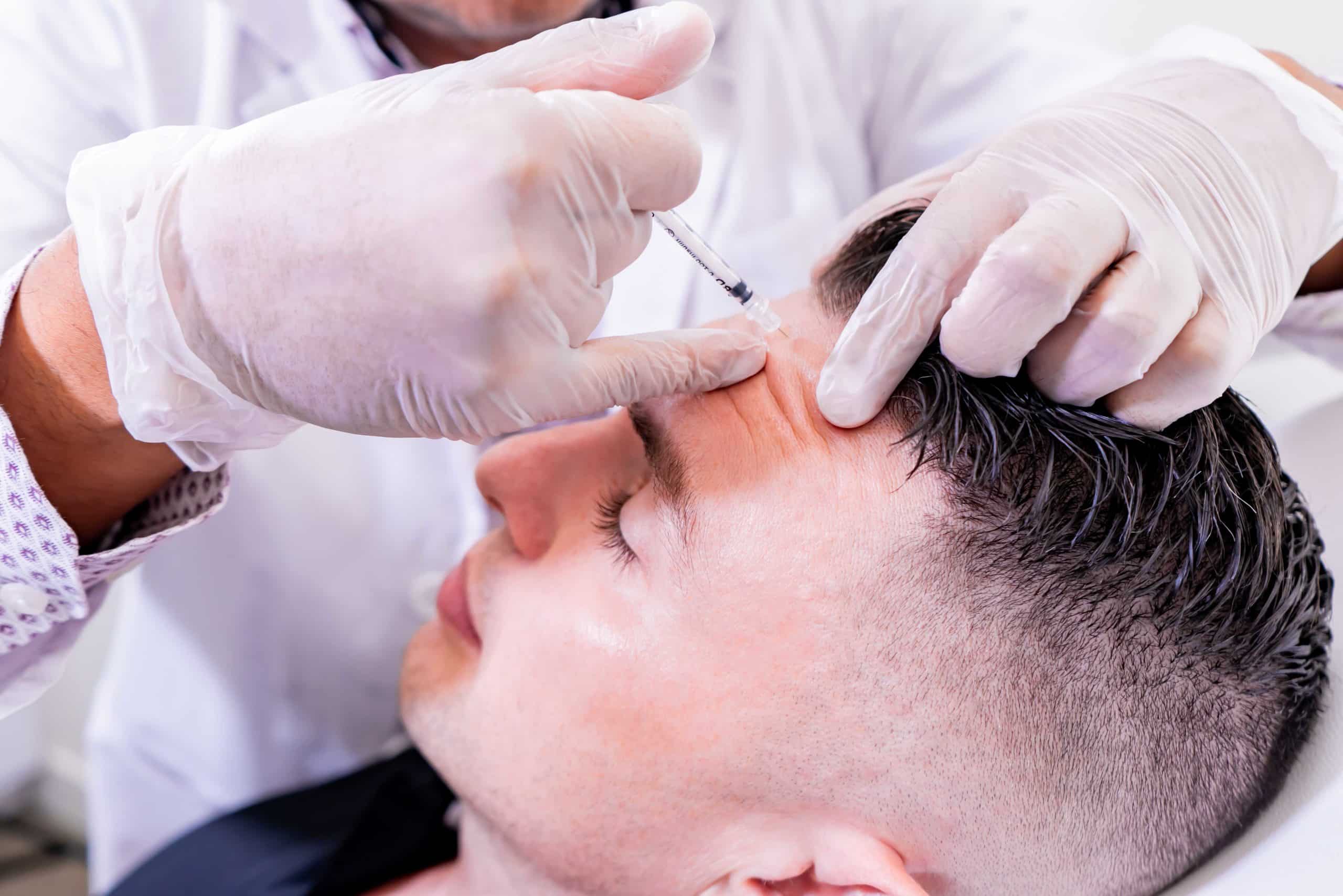 Young handsome man getting botox injection on forehead | La Lumiere Esthetique in Dallas, TX